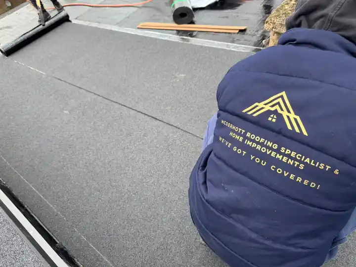 McDermott roofer laying felt on a flat roof