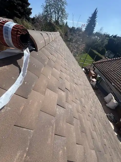 Dry ridge roll being fitted along a new plain tile roof