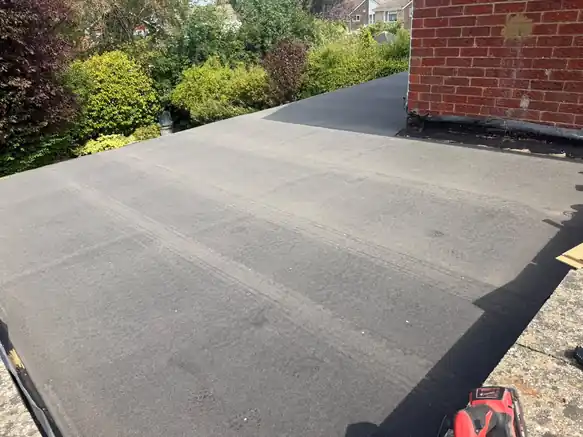 Felt flat roof finished around a brick chimney breast