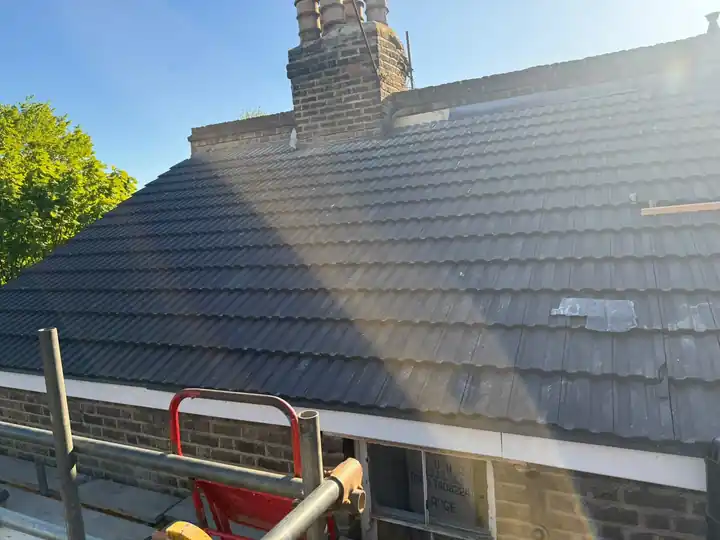 New grey tile roof beside a chimney, finished by McDermott Home Improvements