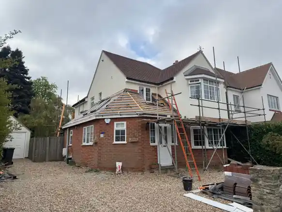 Farnham house under scaffold with the ground-floor bay roof stripped to battens