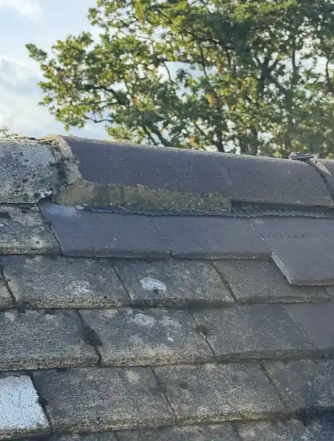 Ridge tiles with worn mortar bedding over old plain tiles