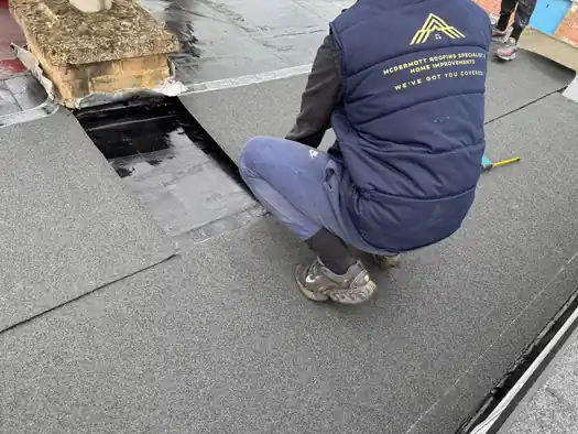 McDermott roofer laying mineral felt on a flat roof