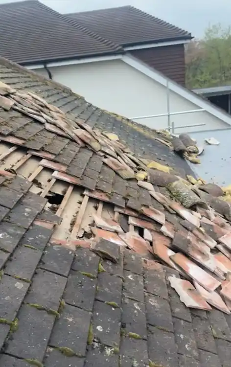 Slipped and broken tiles across an old roof slope