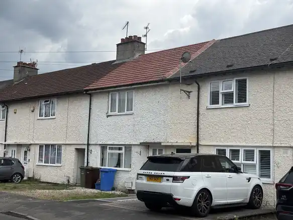 Mid-terrace house with a new red tile roof between its neighbours